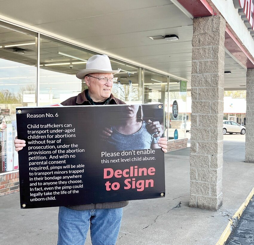 On Friday, April 5, Dan Lowe with the Sedalia Chapter of the Missouri Right to Life holds a sign discouraging petition signers at Bazoo Books. Lowe and several other Right to Life members were on hand for the controversial reproductive freedom petition drive.   File photo by Faith Bemiss-McKinney | Democrat