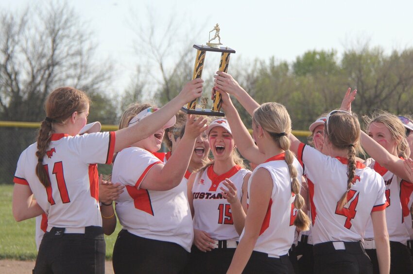 The Northwest softball team celebrates winning the Kaysinger Conference Softball Tournament with the first place trophy in Lincoln Saturday. The team claimed its second straight conference title while remaining undefeated on the season at 12-0.   Photo by Jack Denebeim | Democrat