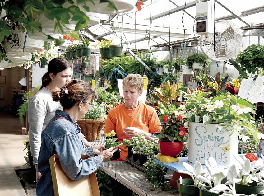 Kim Rimel, right, an agriculture instructor at State Fair Community College, and student Lilie Lett, of Odessa, left, answer a customer's question on Monday, April 29. The SFCC Horticulture Club Plant Sale opened Monday in the college's greenhouses. It will remain open until May 11.   Photo by Faith Bemiss-McKinney | Democrat