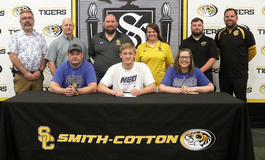 Smith-Cotton High School senior Keaton Belsha has accepted an athletic scholarship to wrestle for Northeastern Oklahoma A&amp;amp;M College. Seated with him at the table are his parents, Gabe and Misty Belsha; back row, from left: Smith-Cotton Principal Wade Norton, Smith-Cotton Wrestling Assistant Coach Chris Johnston, Smith-Cotton Wrestling Head Coach Joe Hulsey, Smith-Cotton Wrestling Assistant Coach Nicki Renfrow, Smith-Cotton Wrestling Assistant Coach Tanner Proctor, and Smith-Cotton Activities Director Kyle Middleton.   Photo courtesy of Sedalia School District 200