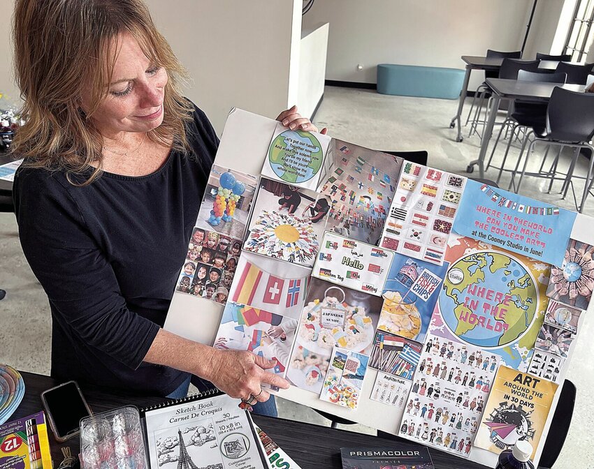 Diane Burnett, director of the Cooney Studio at the Hayden Liberty Center, holds a chart showing various activities for the summer art camps beginning June 3.   Photo by Faith Bemiss-McKinney | Democrat
