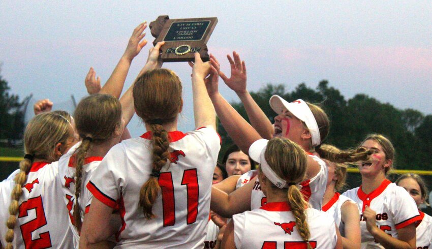 The Northwest softball team celebrates winning the Class 1 District 7 championship with the first place plaque. The Mustangs defeated Lincoln 13-3 Wednesday, May 8, in Warrensburg to advance to the state tournament.   Photo by Jack Denebeim | Democrat