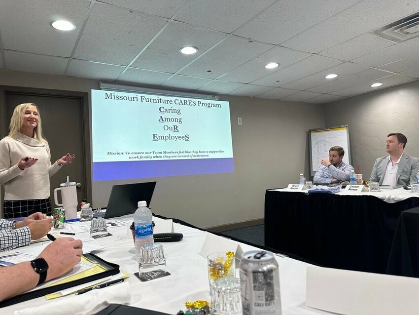 Karen Faiferlick, Owner/Senior VP of Missouri Furniture, presents the business' employee CARES program at a recent company Leadership Summit while sons Grant and Connor look on.