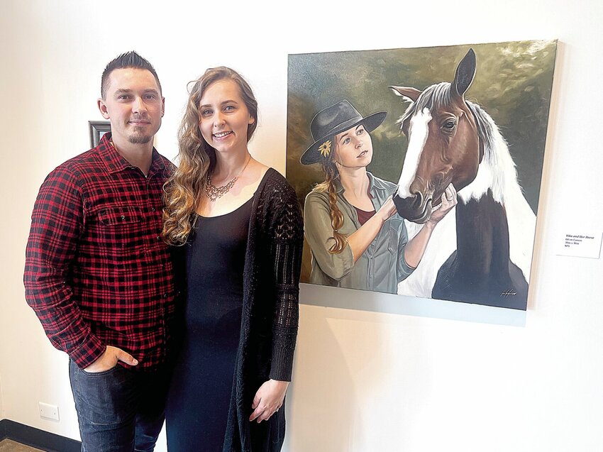 Sedalia artist Ivan Levko stands with his wife, Viktoriya, at his artist reception on Thursday, May 9, at the Hayden Liberty Center. The oil painting &ldquo;Vika and Her Horse&rdquo; is one of Levko&rsquo;s newest pieces.   Photo by Faith Bemiss-McKinney | Democrat