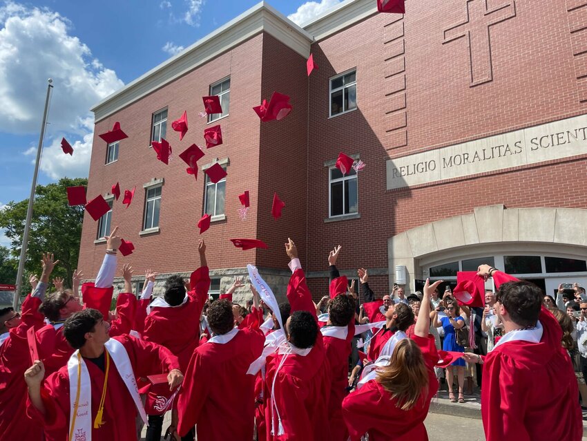 Twenty-eight red caps were flung into the air above the Circle Drive at Sacred Heart School on Sunday, May 19 in celebration of commencement.   Photo by Chris Howell | Democrat