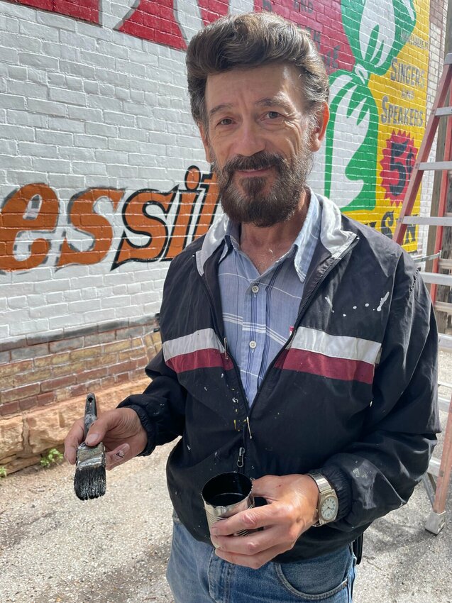 Local sign artist Gary Huddleston was commissioned by Sedalia Main Streets to renew the more than 100-year-old Sen-Sen mural in the alley near Fifth Street and South Ohio Avenue. Huddleston, seen Wednesday, May 22, said he never imagined he would be called to do the restoration.   Photo by Chris Howell | Democrat