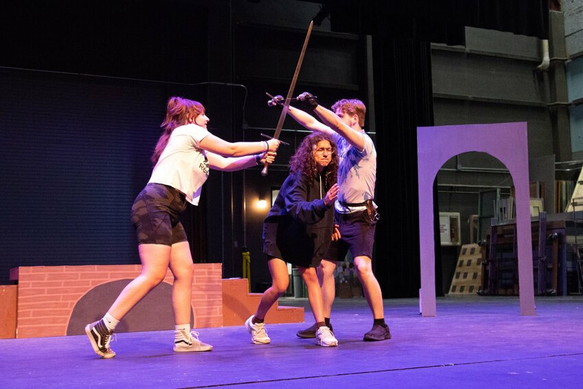 Guinevere (Grace Clark), center, holds her breath as Lancelot (Quinn Allen), right, fights to save her from the evil Mordred (Claire Groos) during a rehearsal for &ldquo;Guinevere and Lancelot&rdquo; on Wednesday afternoon, May 22 in the Highlander Theatre at the University of Central Missouri.   Photo by Nicole Cooke | Democrat