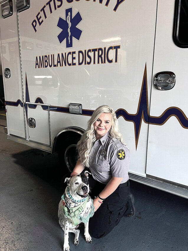 Pettis County Ambulance District Paramedic Emma Smith,22, sits with her dog, Leila, at PCAD Station 1 on Friday, July 12. On Monday, July 8, Smith and her PCAD partner, EMT Matt Kowalski, received lifesaving awards for saving the life of a pediatric patient.   Photo by Faith Bemiss-McKinney | Democrat