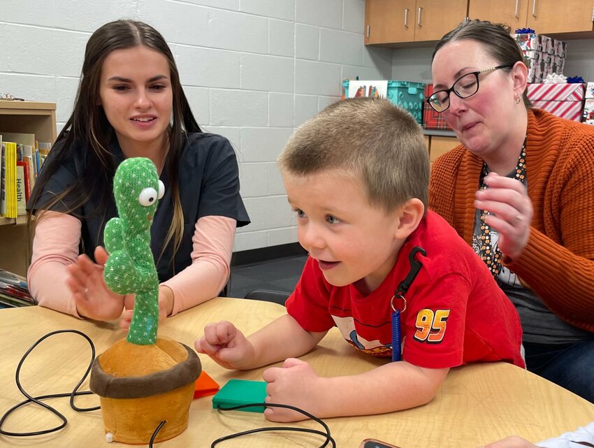 Sadie Blankenship and Mariah Navarro watch Gregory Siegel on Wednesday, Nov. 20, as he operates a gifted dancing cactus customized with a switch he can easily operate.   Photo by Chris Howell | Democrat