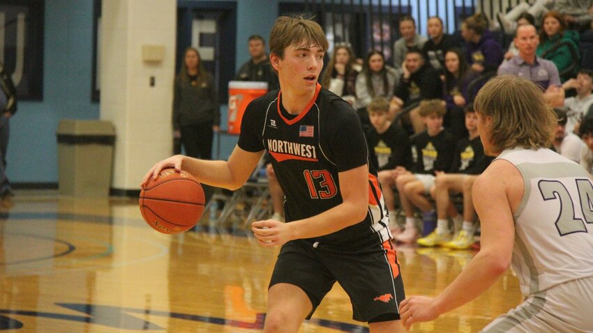 Northwest senior Tanner Johnson dribbles the ball as he scans the defense during the Kaysinger Conference Tournament game against Green Ridge on Saturday, Feb. 1, at State Fair Commnunity College.   Photo by Jack Denebeim | Democrat