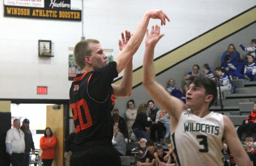 Stover junior Vincent Karstens (20) shoots a 3-pointer while being challenged by Warsaw senior Garrett Ferguson (3) during the Class 3 District 13 Tournament semifinal game on Wednesday, Feb. 26, at Windsor High School.   Photo by Jack Denebeim | Democrat