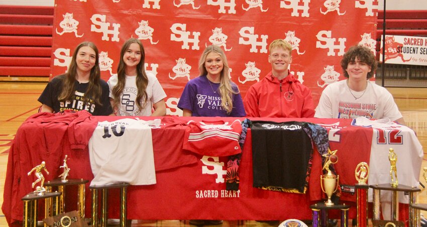 Sacred Heart seniors, from left to right, Grace Sproston, Joleen Frost, Charlotte Carroll, Zander Jackson and Conner Brown celebrate taking their athletic careers to the collegiate level during Commitment Day on Wednesday, April 23, at Sacred Heart High School.