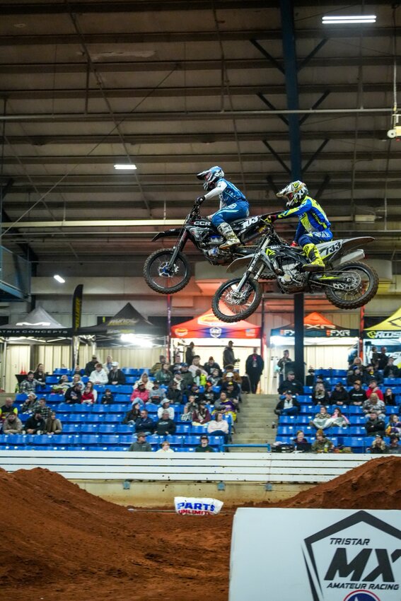 Drivers perform big air jumps in a standard Arenacross race.