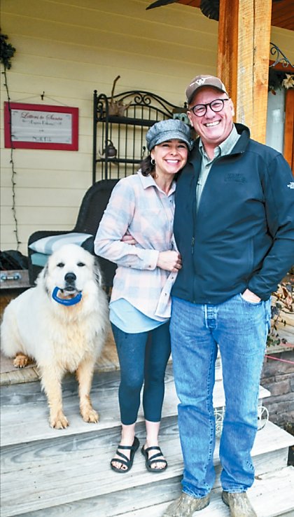 Charles and Rhonda Williams, owners of Doddy Creek  Farms, pose on the front porch of their home with their  dog Doddy.