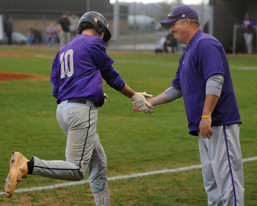 Coach Robbie Davis congratulates Dylan Norris as he rounds third after his solo home run in the first inning on Monday at Cascade.
