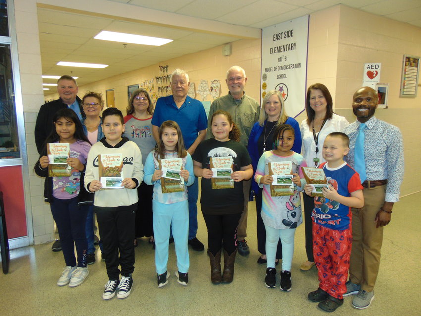 Members of the Duck River Watershed Education Committee, some of whom are in the back row, delivered booklets and bookmarks to Bedford&rsquo;s third and fourth graders. Pictured in the front row are students from East Side Elementary.