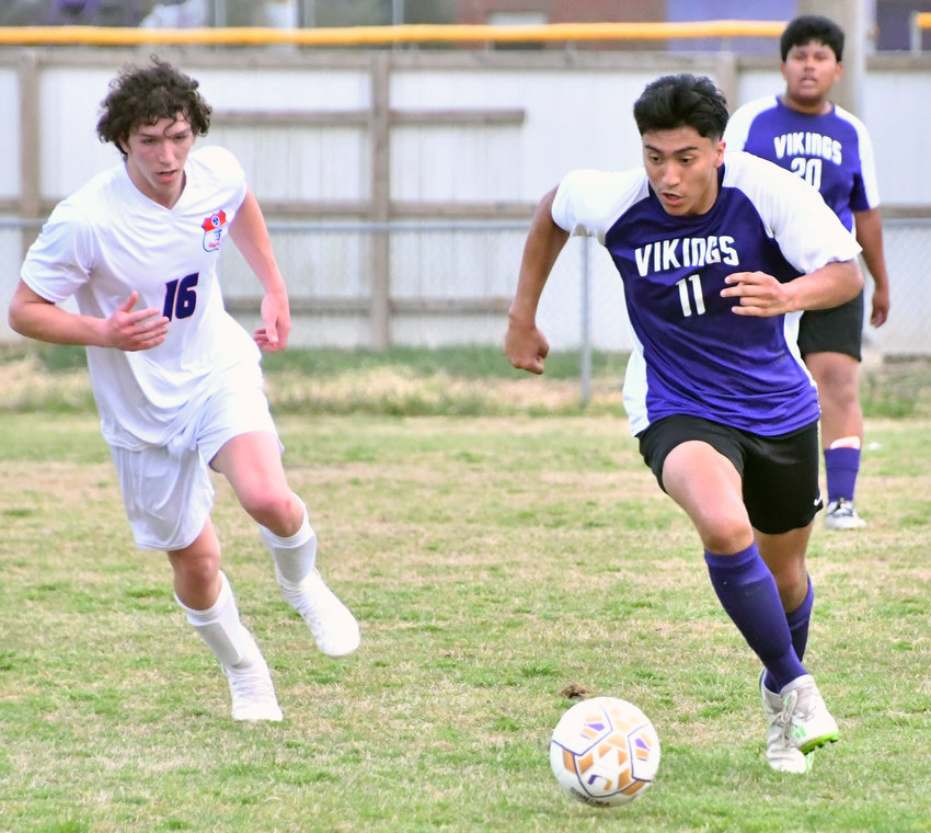 Ramon Hernandez (11) of the Vikings guides the ball up the field with Haiden Penrod (16) of the Rockets in pursuit.