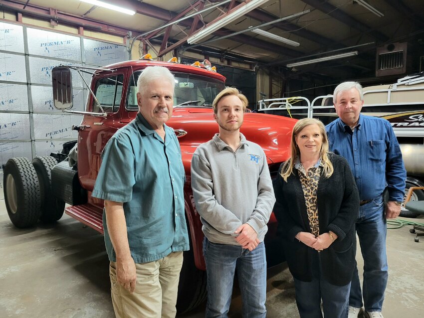 From left Car Club President Walt Bagar, Chase Clanton, Secretary Phyllis Clanton, and Board Chairman Jerry Clanton. Behind them is the first commercial truck Jerry ever drove, a 1956 Ford F800.