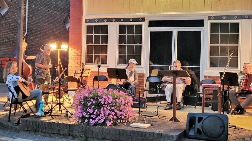 On downtown Normandy’s front steps, many of the musicians warm up as they get ready to play bluegrass-style worship music.