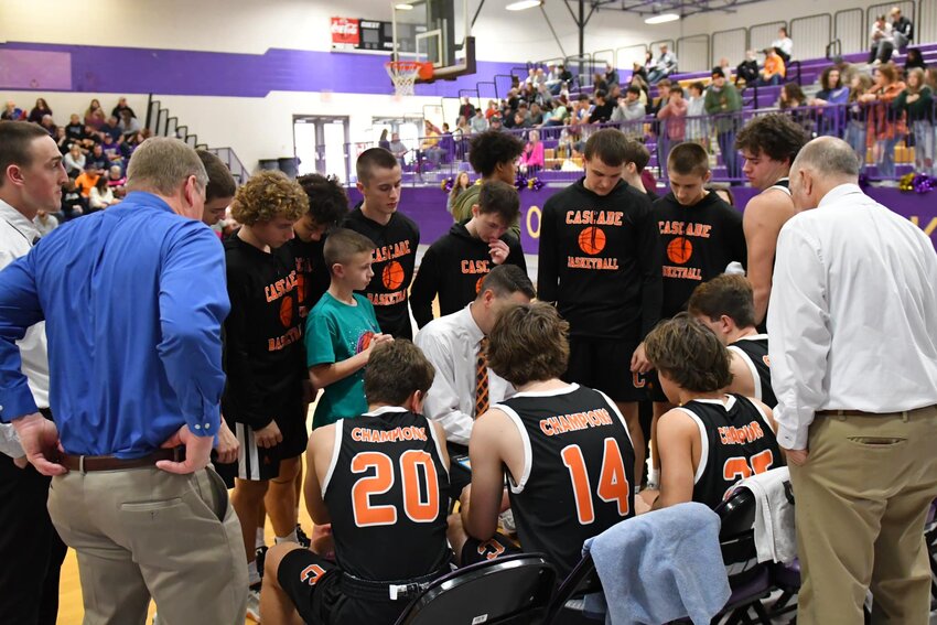 Cascade head coach Chris Lawson (middle) talks to his team during a timeout in their win at Grundy County on Saturday.