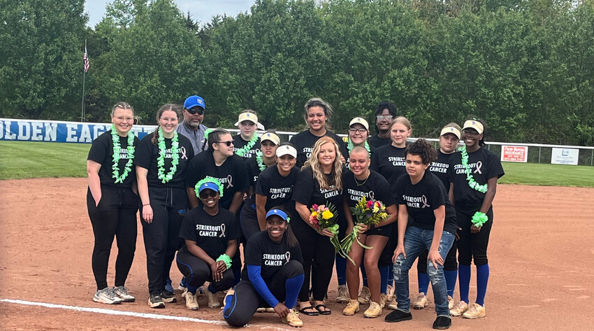 The Shelbyville Central Golden Eaglettes pose with Alyvia Smith (right, holding flowers) after she threw out the first pitch on Saturday.