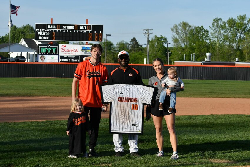 Jared Carkuff (left) poses with Travis Sheffield (middle) as his #10 jersey becomes the first to be retired prior to game two against Grundy County.