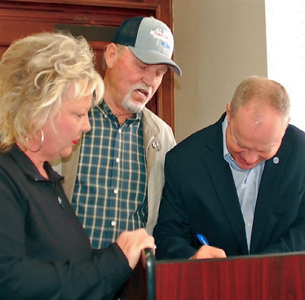 Bedford County Mayor Chad Graham signs a proclamation at the courthouse with Donna Orr, county ambassador for Donate Life and Wayne Carter, accepting the document on behalf of all those who have received organs or tissues in this county.