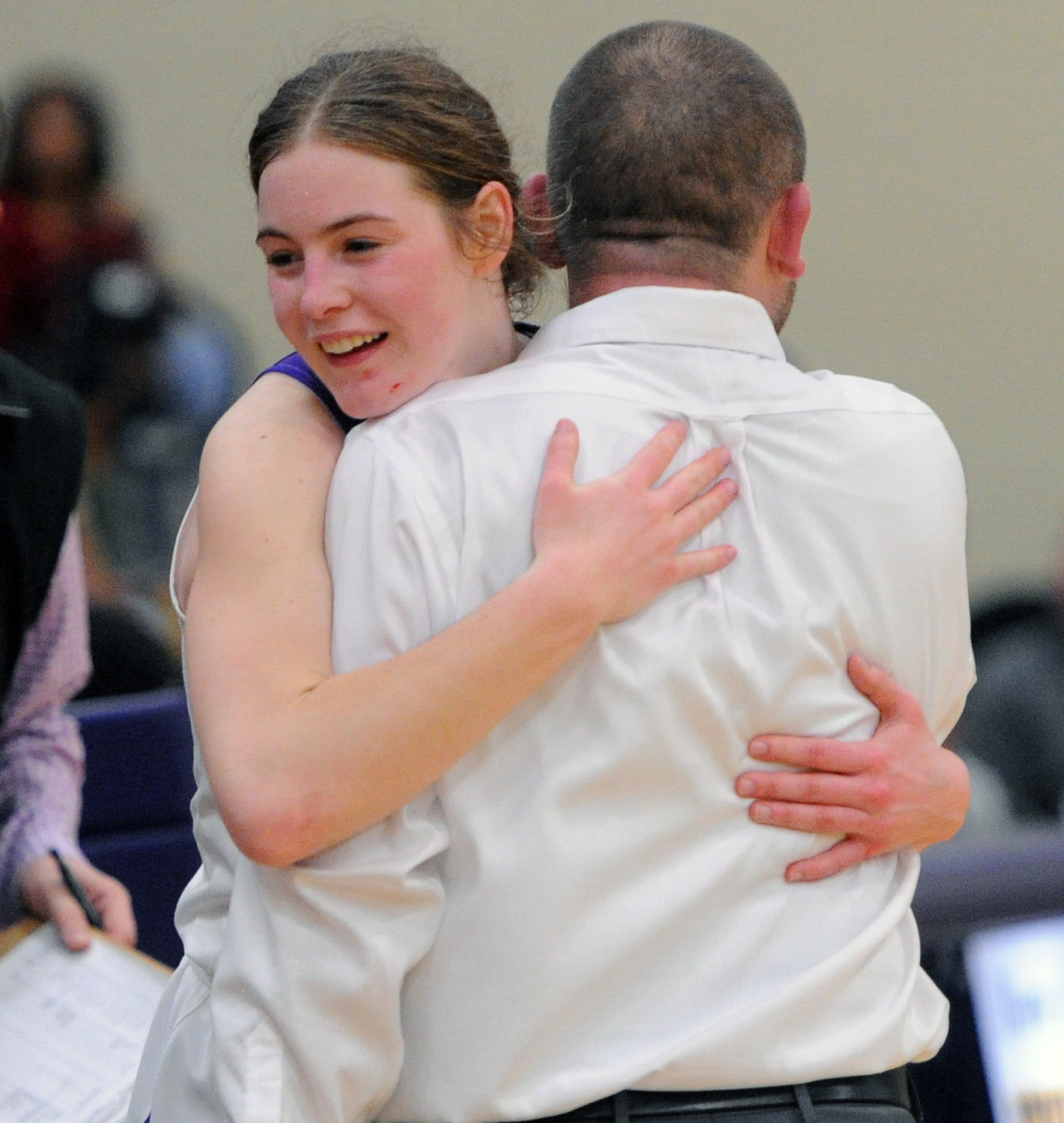 Viqueen senior M.J. Simmons gets a big hug from coach Cody Pierce after exiting the floor in Wednesday night’s Region 4-AA title game.