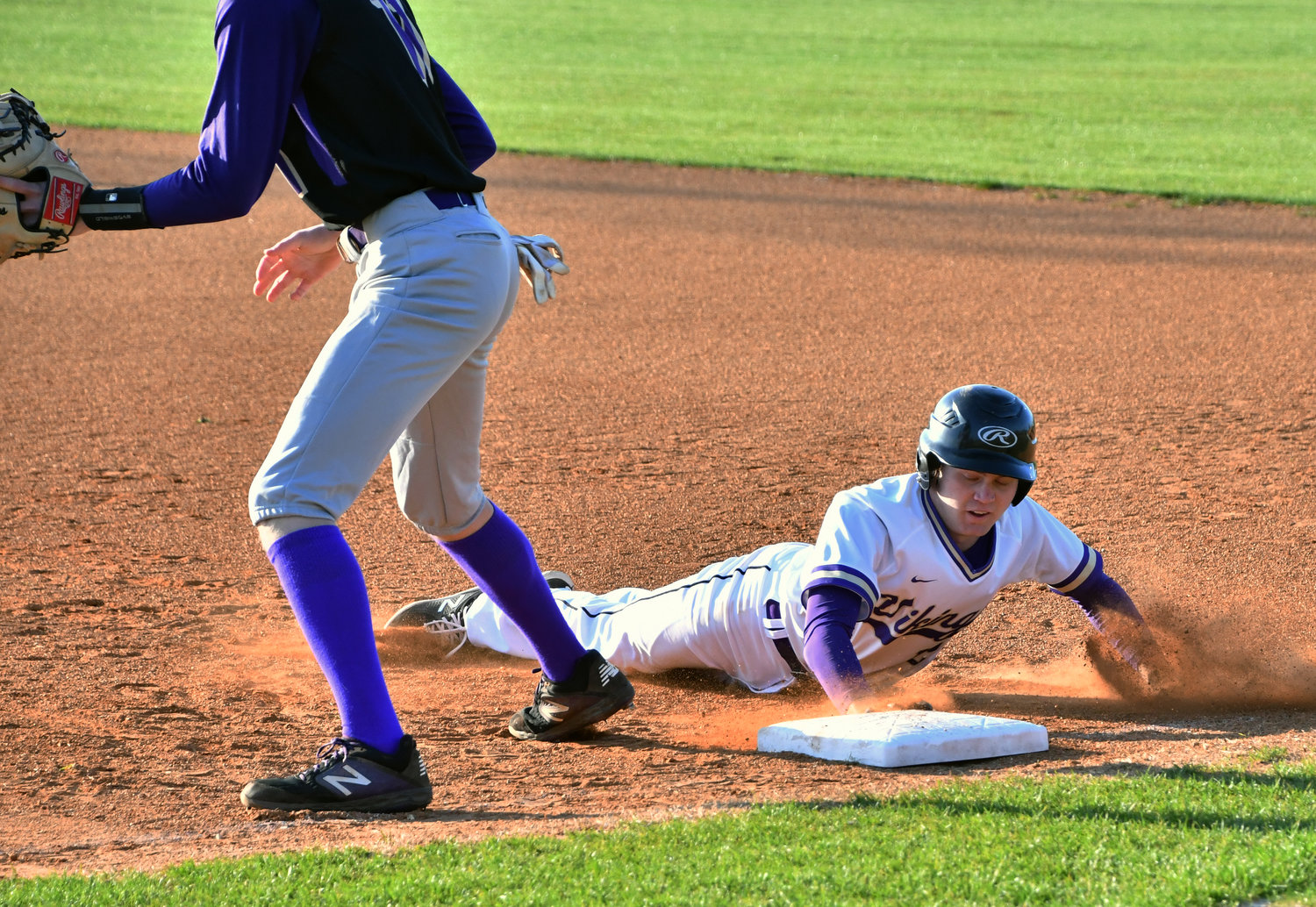 Corey Paterick of the Vikings dives back to first in the opening inning. Paterick was the winning pitcher and struck out five over three innings of work.