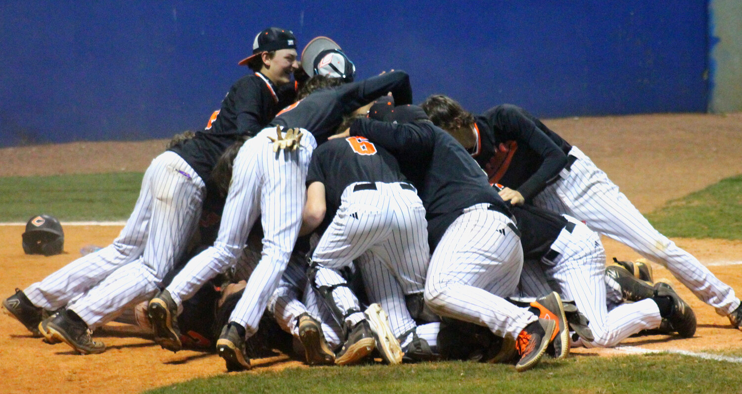 The Champions dogpile on the infield after the final run scored in Saturday night’s championship.