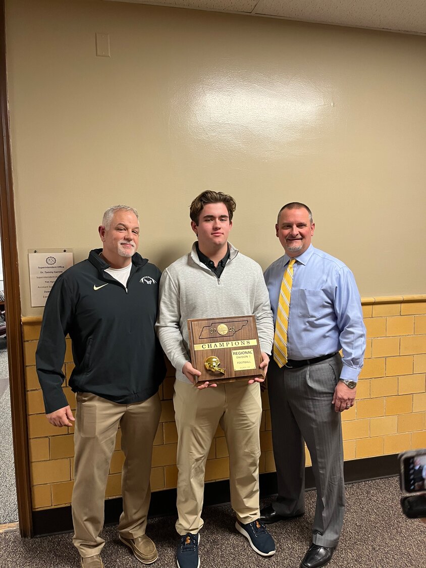 (Left to Right) Shelbyville Central's Football Head Coach Jud Dryden, Senior Ean Matusek, and Principal Charlie Pope holding the Region 5-AAAAA First Place plaque.