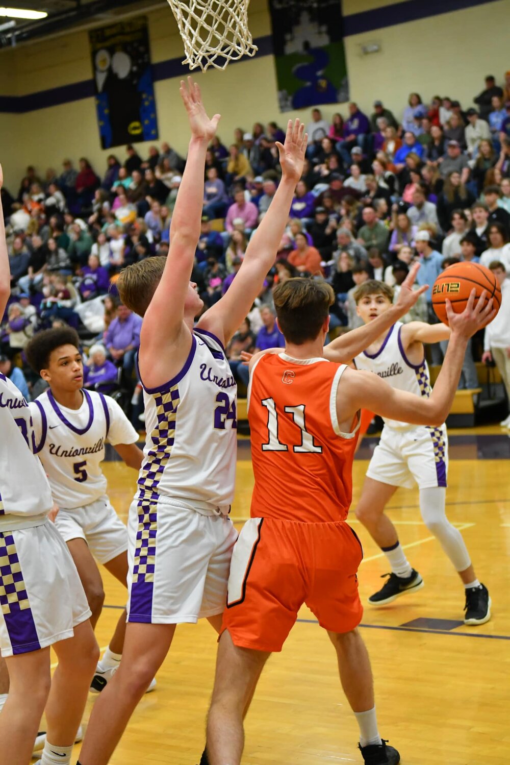 Cascade's Zach Crosslin (11 orange) looks for a pass against Community's Austin Stickler (24 white). Stickler had 15 points for the Vikings while Crosslin led the Champs with 12 points.