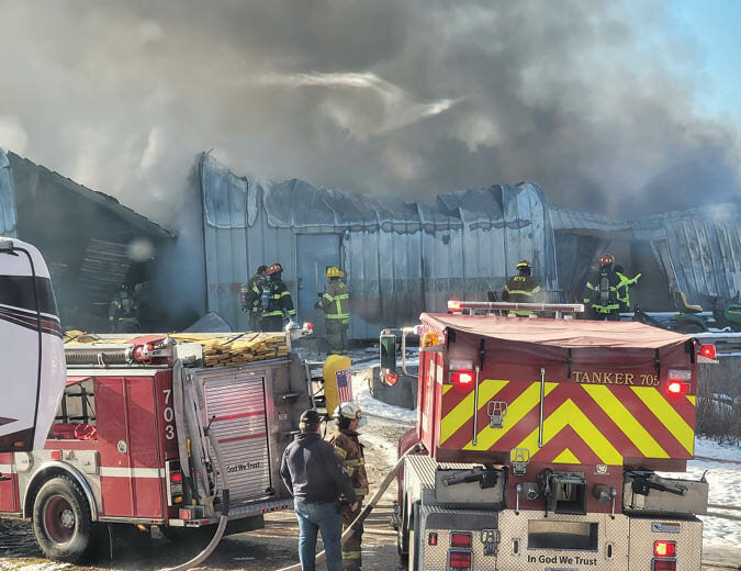 Firefighters from several White County districts work to prevent a massive fire from spreading at a business on Roberts-Matthews Highway.