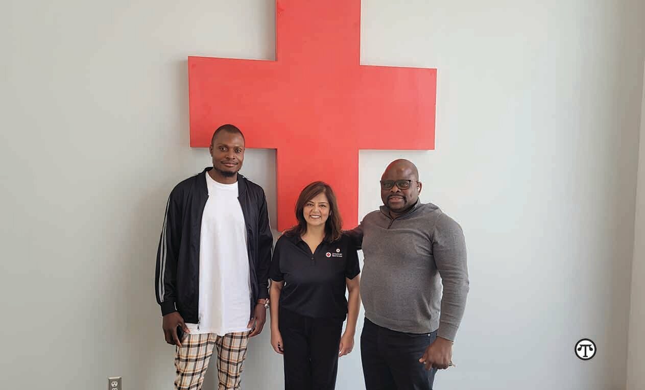 Franck Mputu Beya and Kazadi “Ray” Ntambwe smile with their Restoring Family Links caseworker Muneera Didarali. She helped Franck reconnect with his sister after eight years.