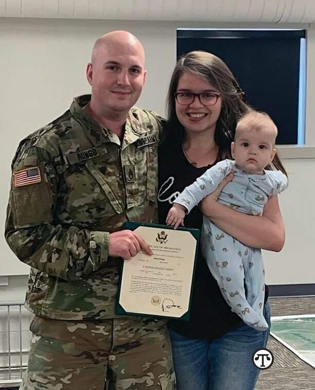 Daniel Rungo takes a family photo with his wife and daughter after his enlistment ceremony with the U.S. Army.