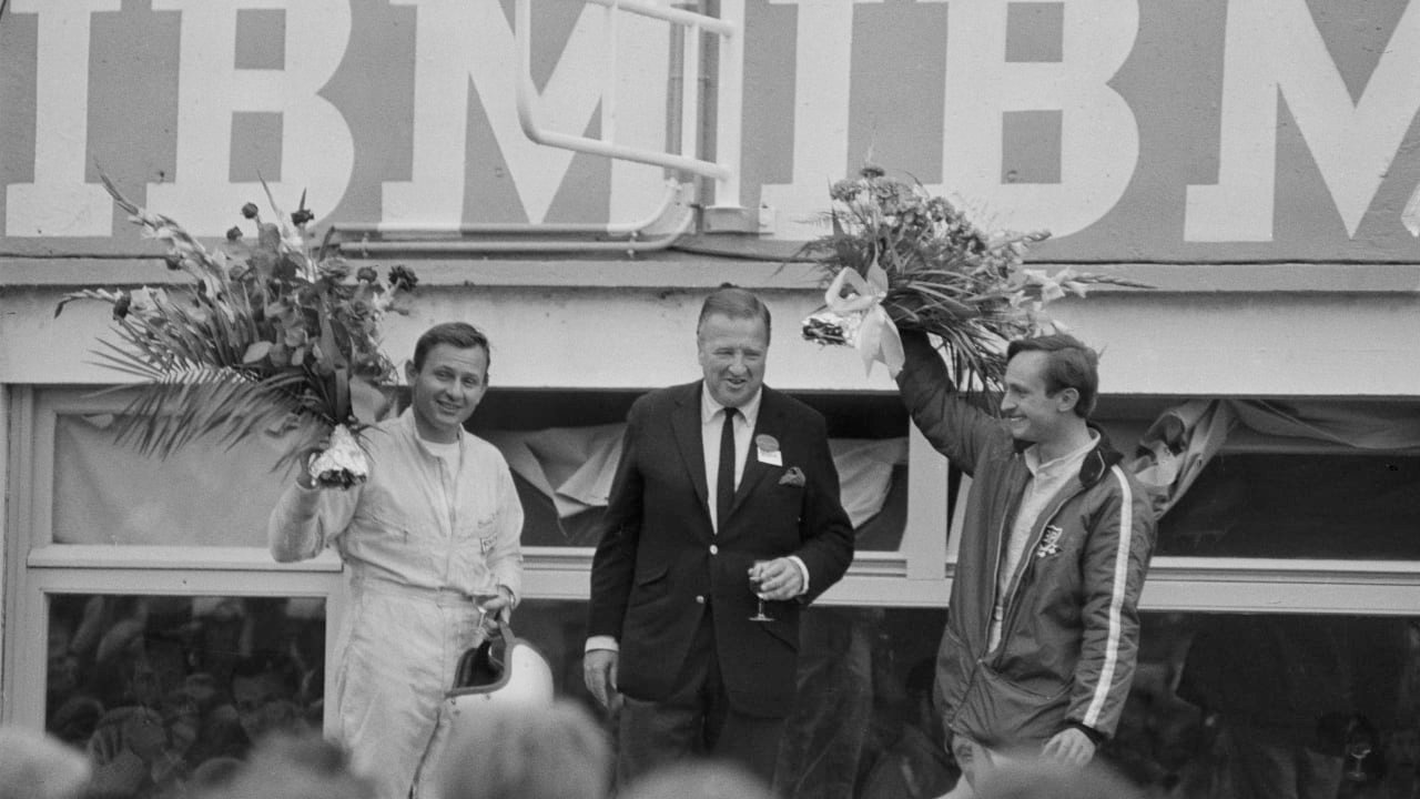 Henry Ford II standing center with Bruce McLaren (left) and Chris Amon (right), winners of the 1966 24 Hours of Le Mans. The victory ended Ferrari's long-running dominance of the endurance race and Ford's personal quest to dispatch the Italian company on their own European turf.