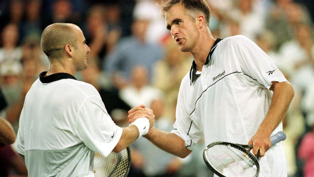 Todd Martin (right) congratulates Andre Agassi for winning the 1999 US Open. Martin was twice a grand slam finalist: at the 1994 Australian Open where he lost to Pete Sampras in 3 sets and at the 1999 US Open where he succumbed to Agassi in a 5-set, hard-fought duel.