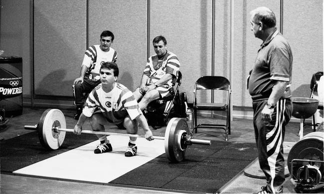 Ivan Abadjiev seen standing and watching his greatest weightlifting protege, Naim Suleymanoglu, attempt a clean and jerk.