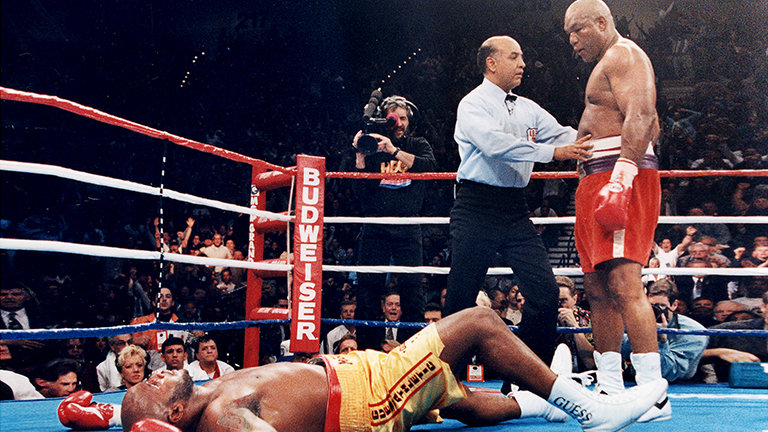 George Foreman standing over Michael Moorer at his comeback match for the world heavyweight title on November 5th, 1994.