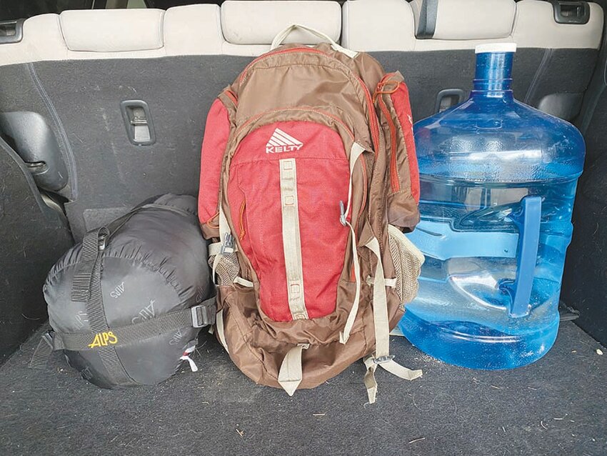 This old backpack now serves as a go-bag and resides in the back of a vehicle. Water and a sleeping bag are also ready.