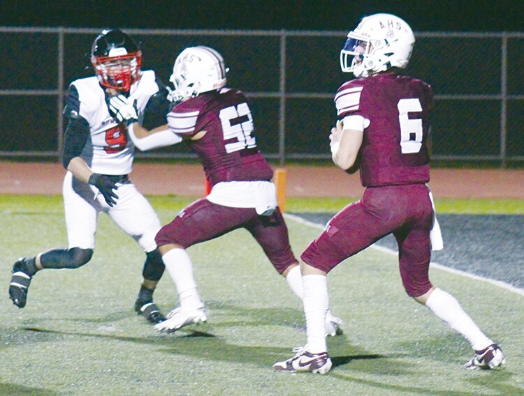 Alamosa High School's Dyson Woodward (6) prepares to launch a 92-yard touchdown pass as Josh Gonzalez (52) blcoks Gunnison's Tate Taramarcaz (9). The Mean Moose defeated the Cowboys 44-15 Friday at the AHS stadium.