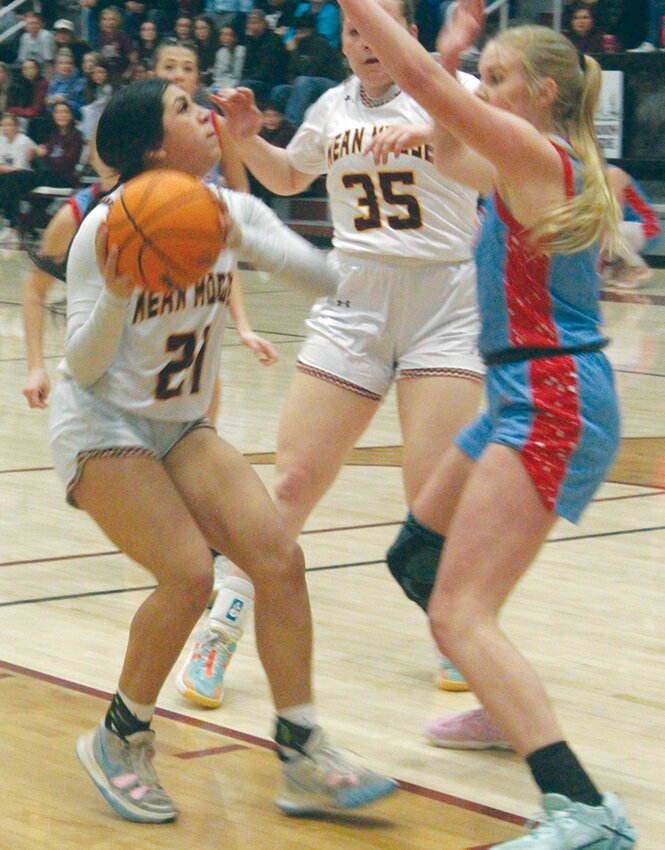 Alamosa High School’s Leela Gutierrez (21) looks to put up a shot in Friday’s Class 4A regional tournament game against Weld Central, while Kadie Hawkins (35) stands by. The Lady Mean Moose defeated Weld Central 41-29 on Friday and Kent Denver 46-41 on Saturday to advance to the Class 4A Great 8 which begins today at the Denver Coliseum.