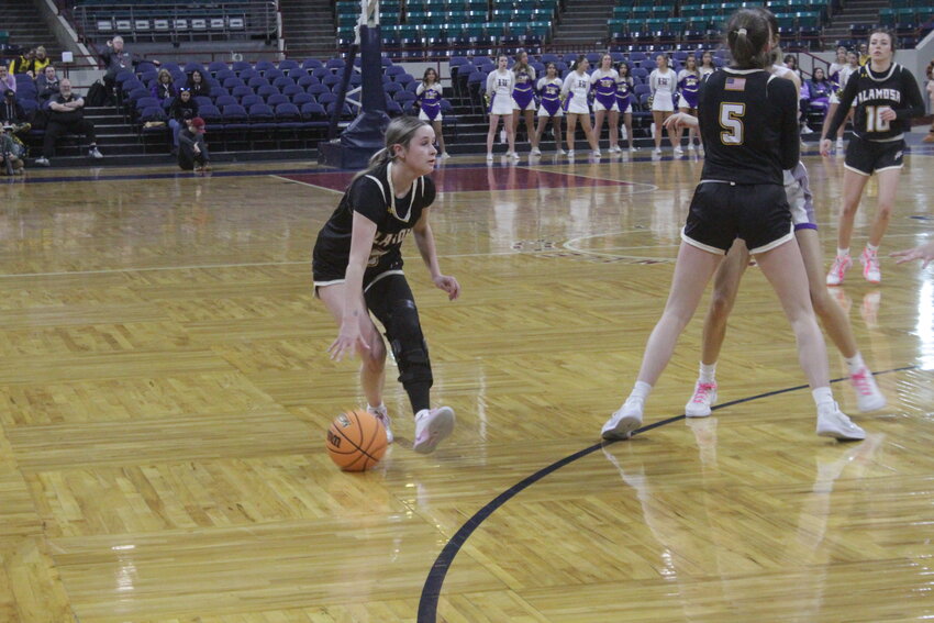 Alamosa High School's Morgan Ortega dribbles the ball in Wednesday's Class 4A State Tournament quarterfinal game against Holy Family at the Denver Coliseum. Ortega scored 13 points in her final game, but the Lady Mean Moose lost to the Lady Tigers, 58-39.