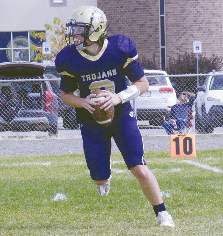 Antonito High School’s Rylan Trant (9) rolls out for a pass in Saturday’s game against La Veta at the Trojans’ field. Trant threw for 136 yards and two touchdowns, but the Trojans lost to the Redhawks 60-12.