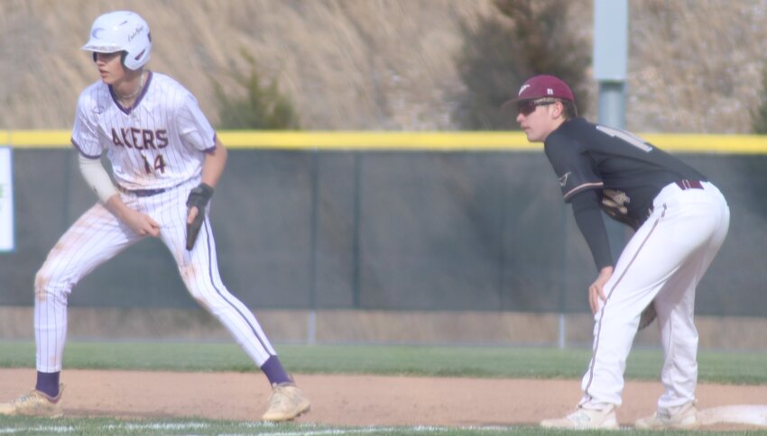 Camdenton's Landon Klee takes his lead off first base while Eldon's Aiden Henley tires to keep him close during the Lakers' 15-0 win over the Mustangs in the 2025 baseball opener at Camdenton.