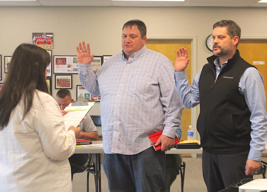 Tipton R-VI School Board secretary Amy Stover swears in Brant Uptergrove, center, for his first term on the board and Bo Helms, for another term, after being elected in the April 8 election. Two board positions became available with this term, with four vying for the title. Ashley Kliethermes’ position, who decided to not run again, was filled by Uptergrove.