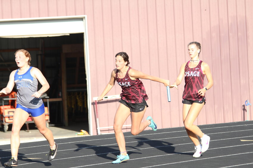 Osage senior Alison Steen receives the baton from freshman Avery Sperling during one of the relays. The Lady Indians won the 4x100m relay (52.61) and 4x200m relay (1:54.97) at the Osage Invitational on Tuesday, April 16, at the Richard Hampton Track.