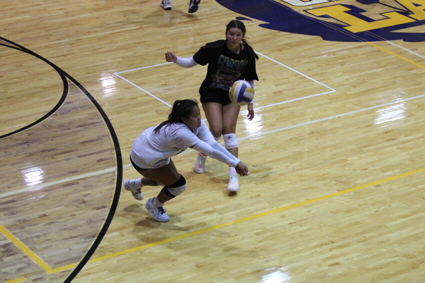 Former Camdenton libero Caitlin Garmany (white shirt) attempts a dig during a practice in the CHS Gymnasium.