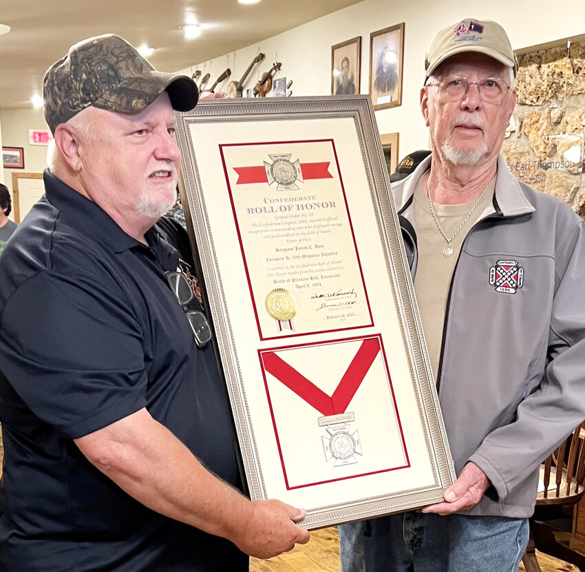 Confederate Sergeant James Castleman Dyer’s descendants Darell Maples and Ken Runge display the Confederate Roll of Honor plaque. It was the second highest honor given by the Confederacy.