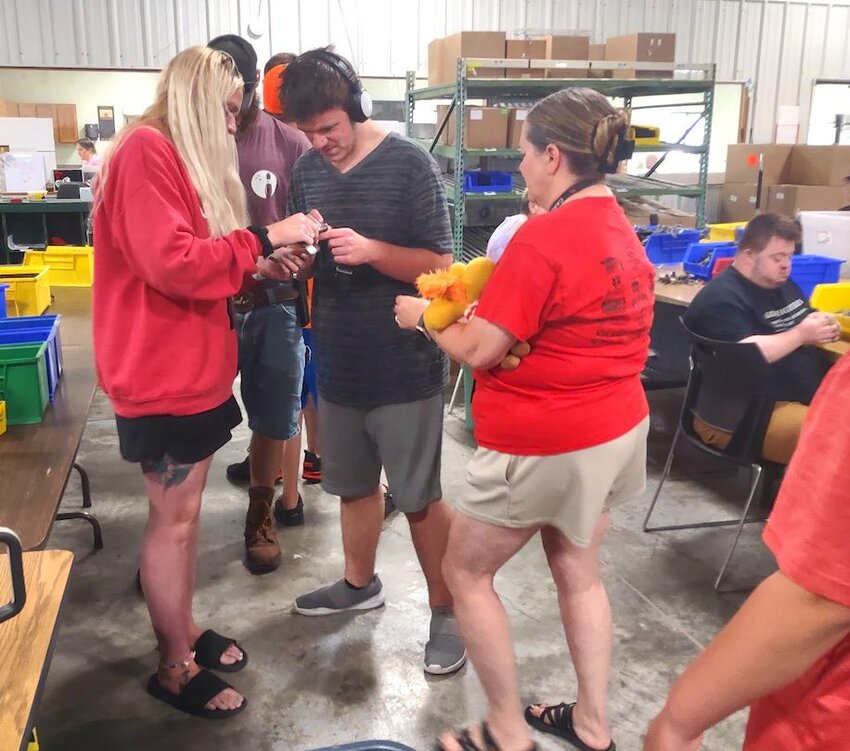 The Tipton High School special education class was able to visit Gateway Industries in Eldon Wednesday, June 11. Pictured is Ashley Coons, para, student Christopher Mickelis, and teacher Anna Diggs, work with a part to see what goes into the job. The plant is a non-profit workshop that is conducted for the purpose of rehabilitation for individuals whose learning capacity is impaired by physical or mental deficiency and cannot compete in traditional work environments. Following the tour of the plant, the students were treated for lunch at Eldon Drive-In and played at the Air Park.